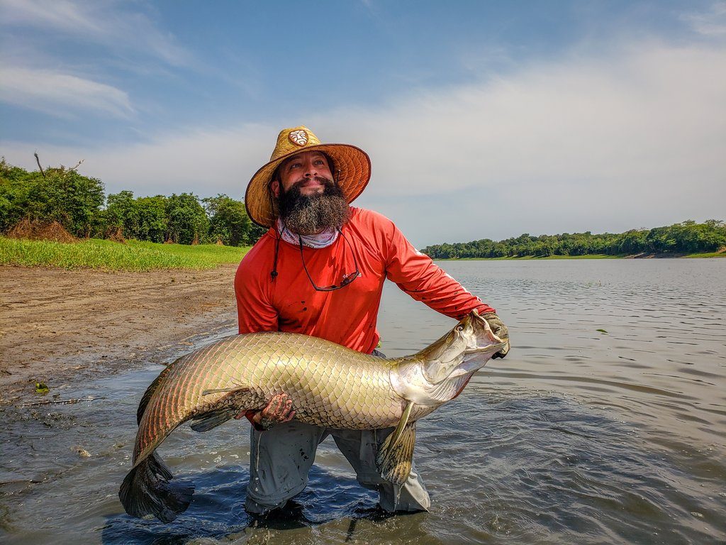 Mann mit Bart hält einen großen Fisch