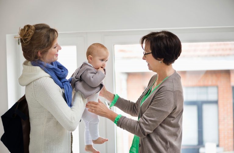 Baby wird von Erwachsenen von Hand zu Hand gereicht