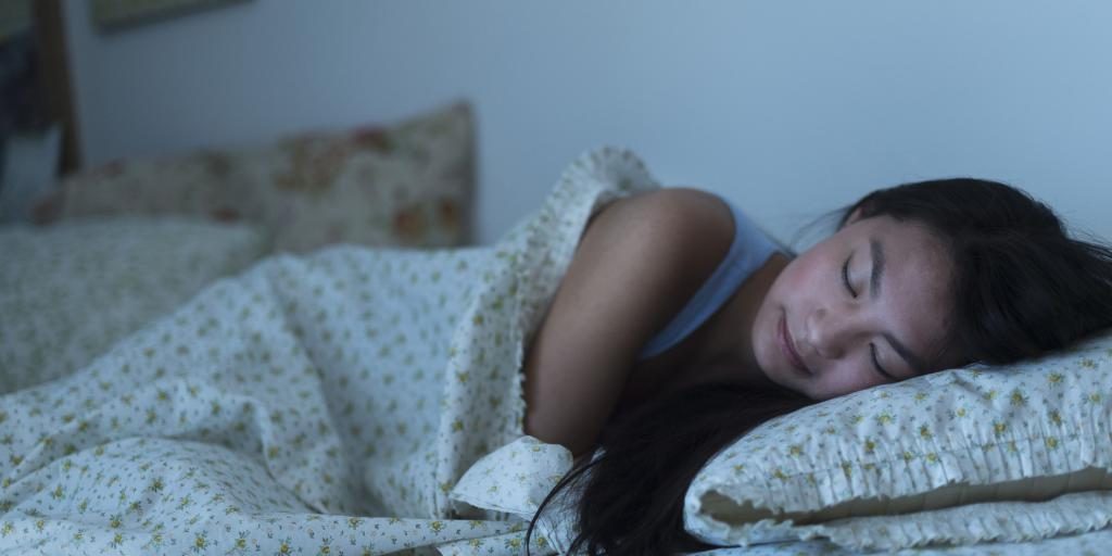 Asiatische Frau schläft im Bett