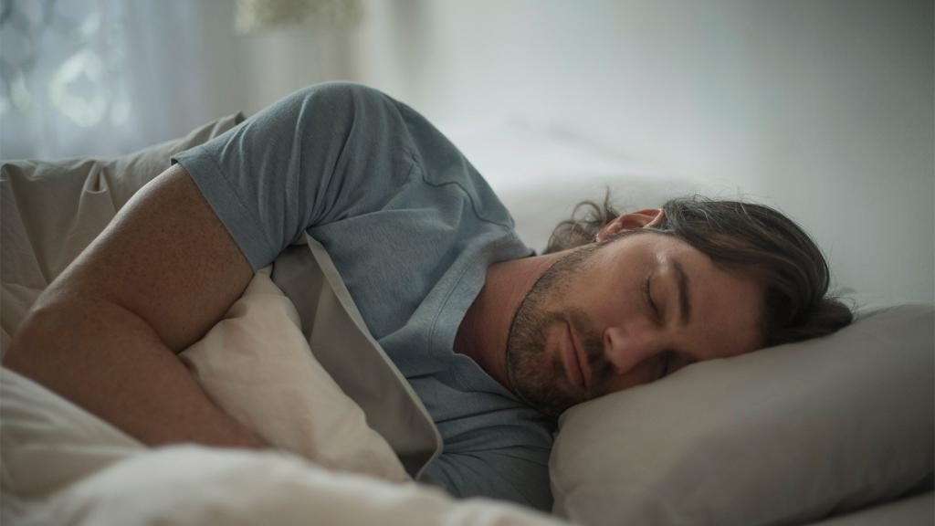 Ein Mann schläft im Bett