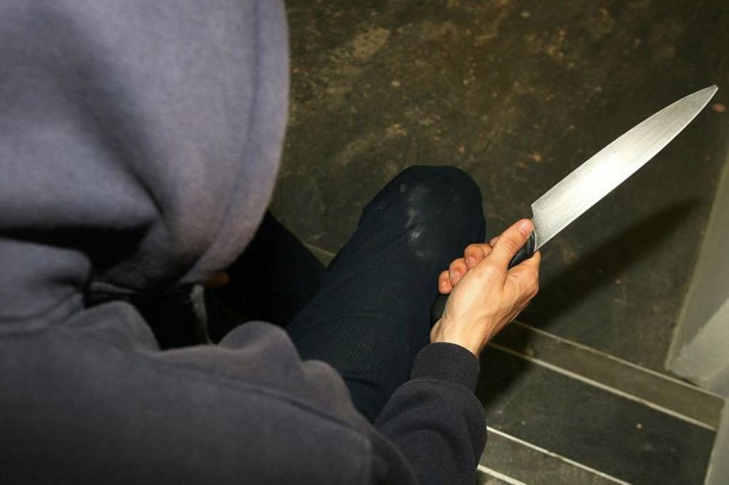 Ein Mann auf der Treppe mit einem Messer