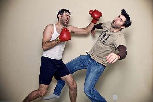 Ein Mann verprügelt einen Kumpel mit Boxhandschuhen.