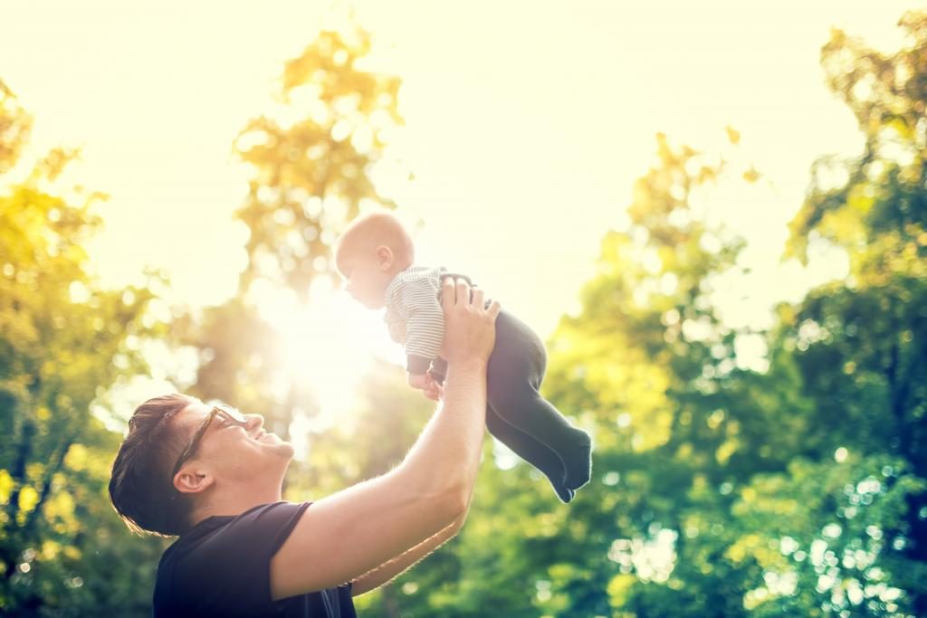 Der Vater spielt mit dem Baby.