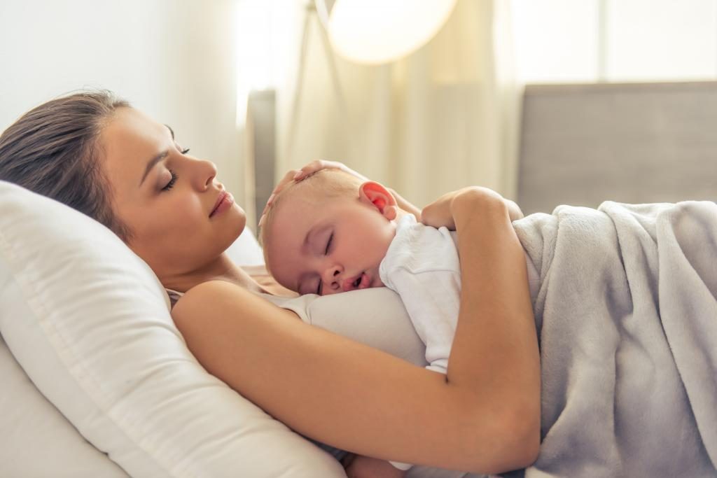 Die Mutter schläft mit dem Baby.